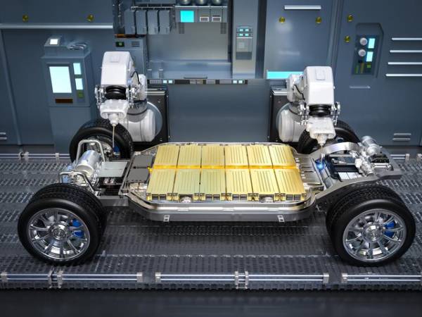 Technician using diagnostic equipment to check electric vehicle battery health
